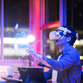 asian young male wearing wearable goggle headset virtual online meeting digital space working with 3d augmented dimension at home,cyber virtual working with virtual vr goggle and pc desktop device